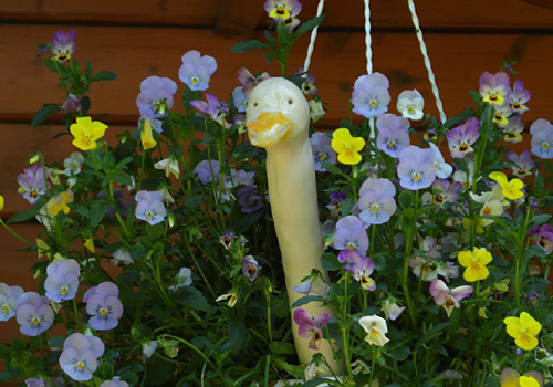 Keramikfigur zwischen Blumen
