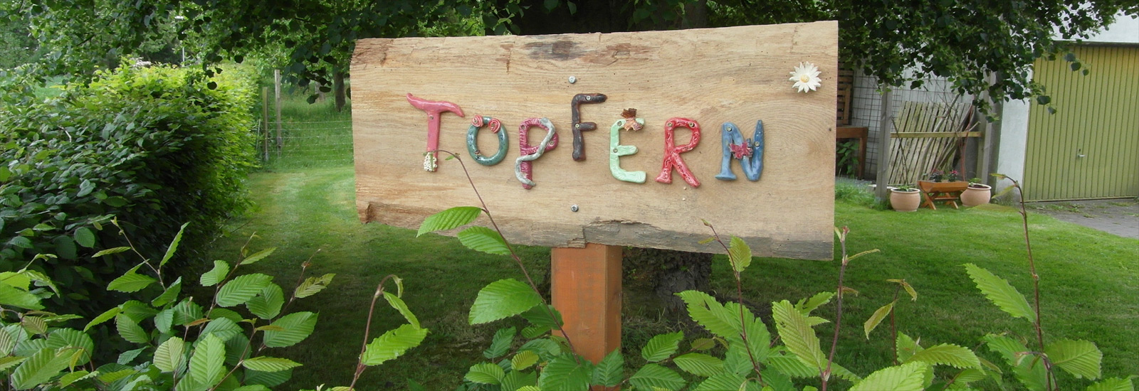 Töpfern-Schild im grünen Garten