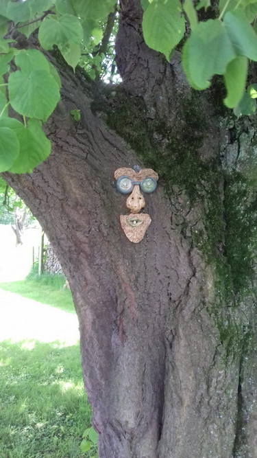Keramikgesicht am Baum