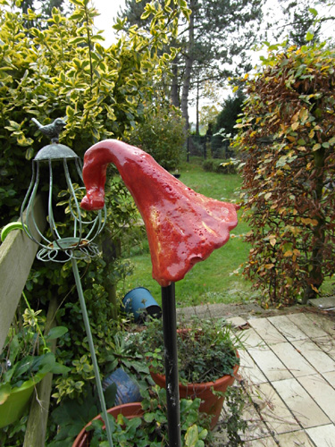 Rote Keramikfigur auf einem Stab